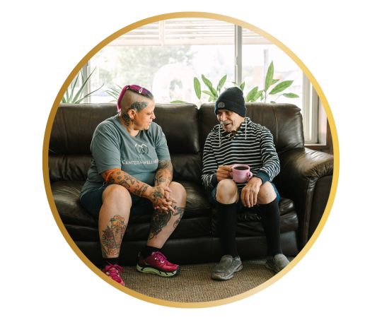 Caregiver talking with client on a couch